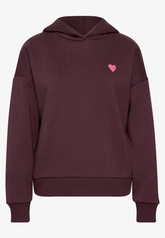 Ein weinroter Kapuzenpullover mit kleinem pinkem Herz-Logo auf der Brust.