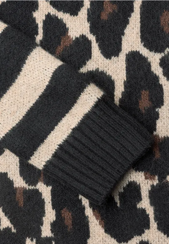 Nahaufnahme eines gestrickten Kleidungsstücks mit beigebraun-schwarzem Leopardenmuster und gestreiftem Bündchen.