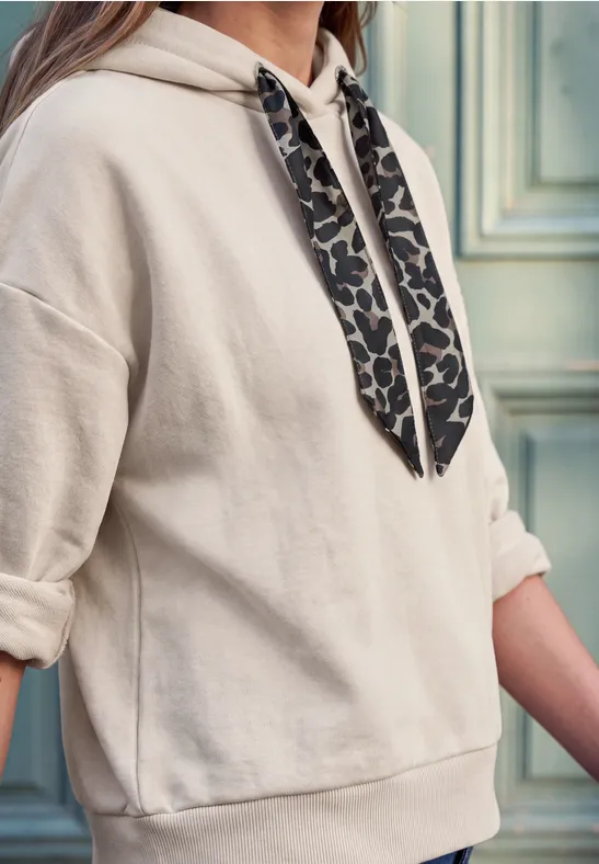 Beige Hoodie mit hochgekrempelten Ärmeln und leo-bedruckten Kapuzenbändern.