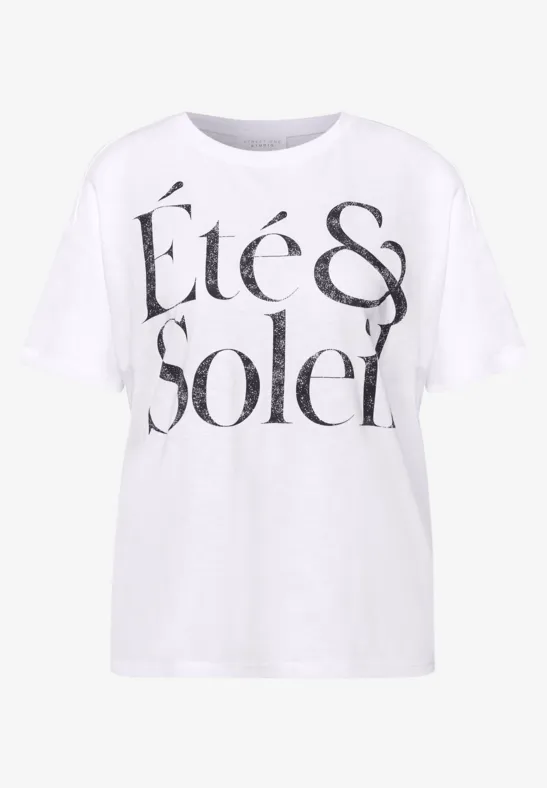Ein weißes T-Shirt mit auffälligem schwarzen Schriftzug 'Été & Soleil' auf der Vorderseite.