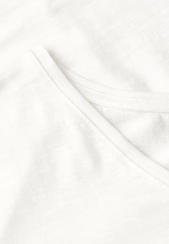 Close-up van een wit katoenen T-shirt met zichtbare stiknaden bij de hals.