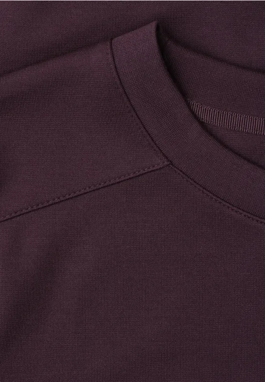 Nahaufnahme eines dunkelvioletten T-Shirt-Kragens aus weichem Stoff.