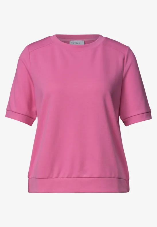 Een roze T-shirt met korte mouwen en ronde hals.