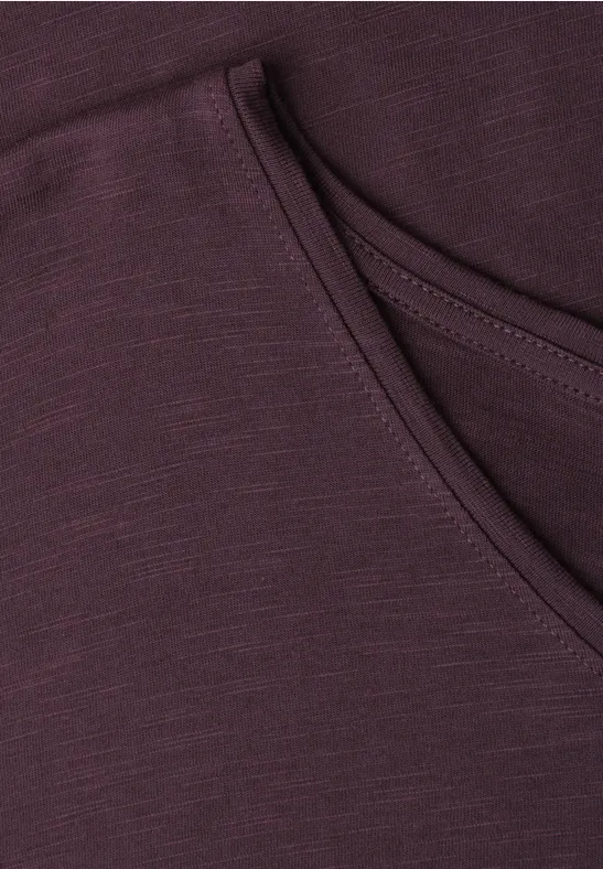 Nahaufnahme einer pflaumenfarbenen Kapuzenjacke mit Kängurutasche.