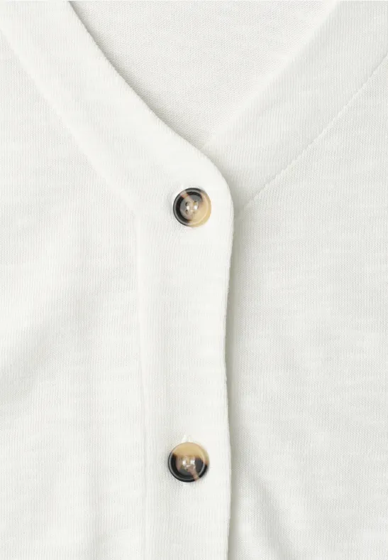 Weiße Strickjacke mit V-Ausschnitt und schwarzen Zierknöpfen