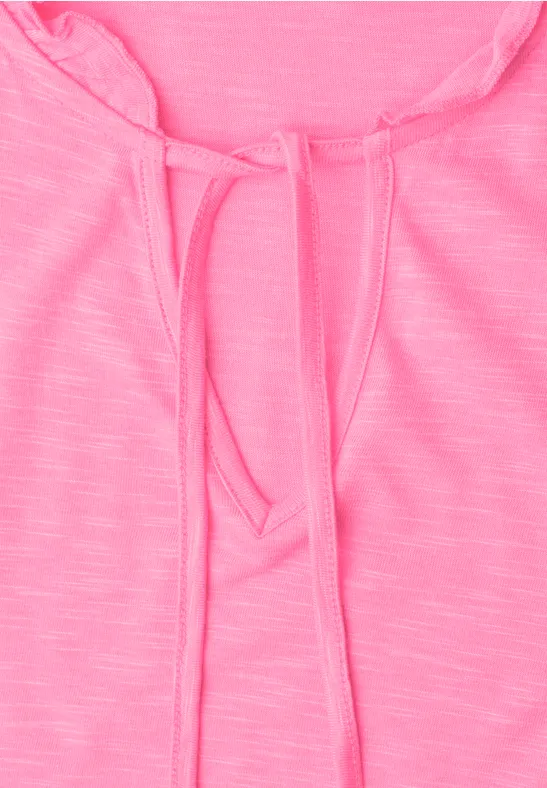 Nahaufnahme eines pinken Shirts mit Tunnelzug am Rundhalsausschnitt.
