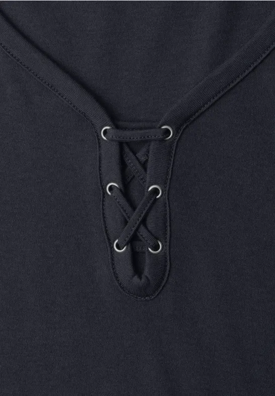 Zwart shirt met V-hals en sierlijk veterdetail in het midden.