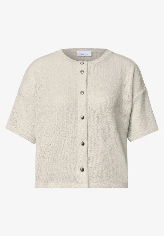 Beige kurzärmelige Strickjacke mit Knopfleiste, rundem Ausschnitt und leichter Struktur.