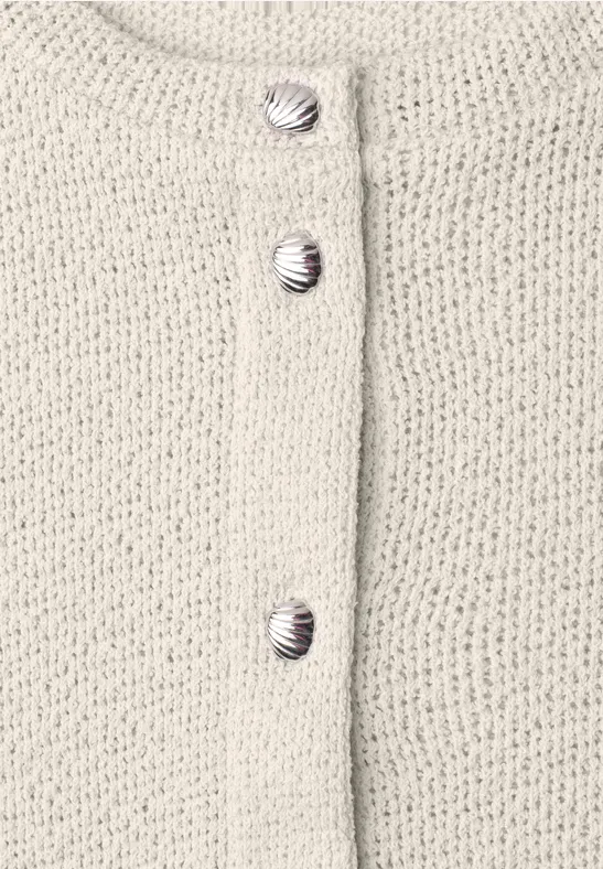 Beige Strickjacke mit drei runden, gestreiften Knöpfen.