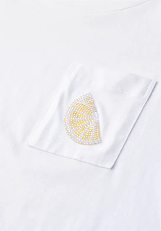 Weißes T-Shirt mit Brusttasche und gelber Zitrusscheibe aus Strass.