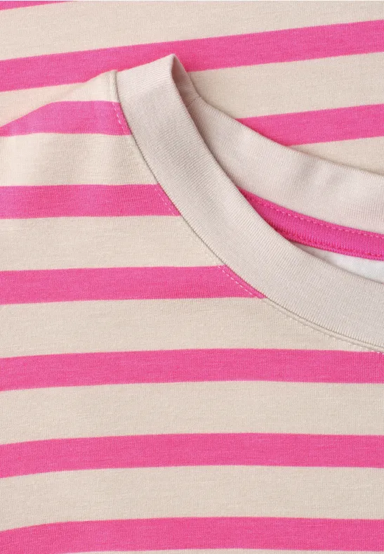Nahaufnahme eines beigen Shirts mit rosa-weiß gestreiftem Muster und Rundhalsausschnitt.