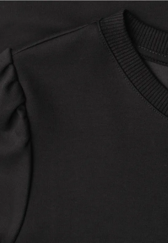 Schwarzes Oberteil mit Rundhalsausschnitt und dezenten Puffärmeln.