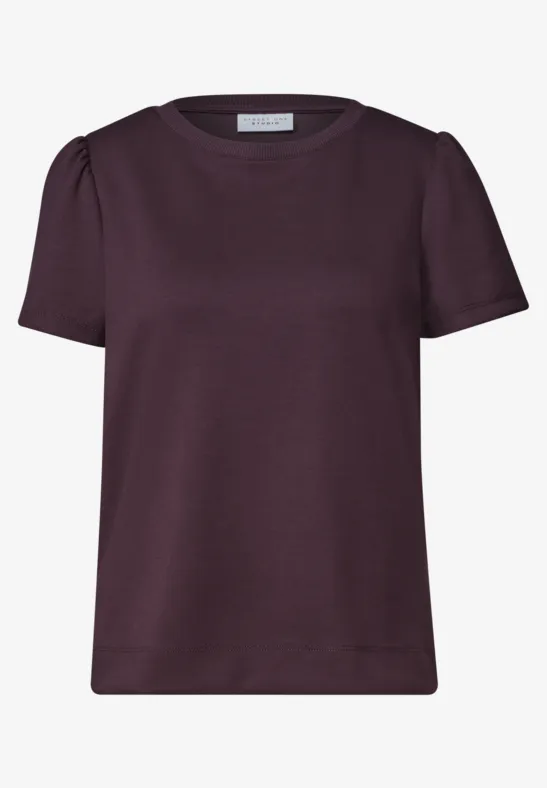 Ein schlichtes, kurzärmeliges Damen-Shirt in dunklem Pflaumenton mit dezenten Schulterraffungen.