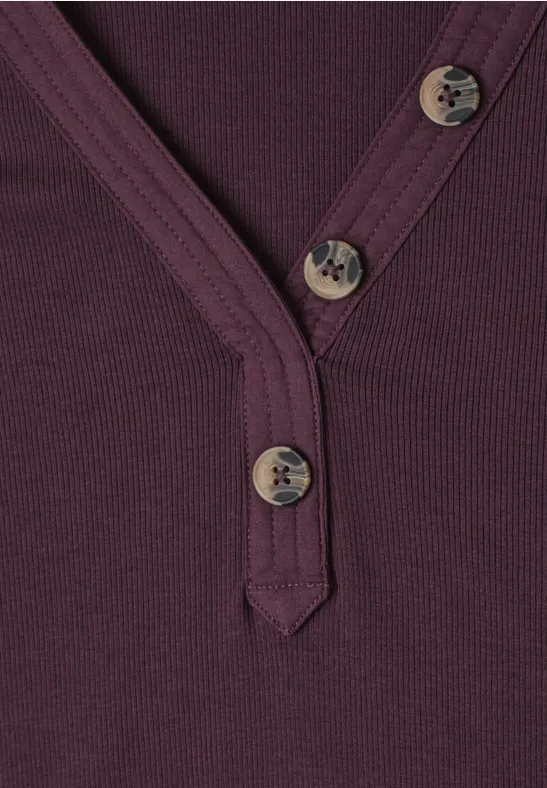 Lila V-Ausschnitt-Shirt mit drei Holzknöpfen und feiner Rippenstruktur.
