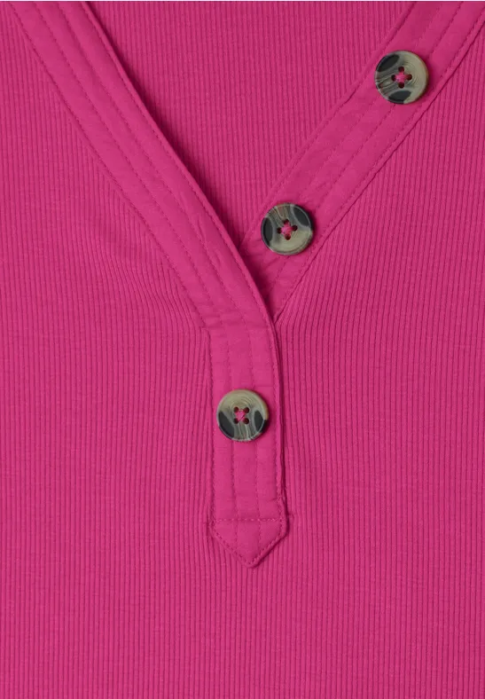 Magenta-pinkes, geripptes Oberteil mit V-Ausschnitt und drei grauen Knöpfen mit Blumenmuster.