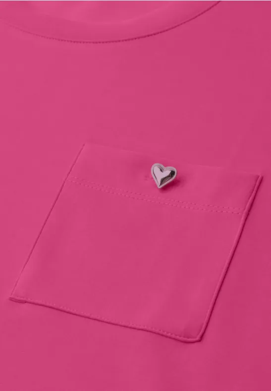 Pinkes Shirt mit Brusttasche und kleinem herzförmigem Anstecker