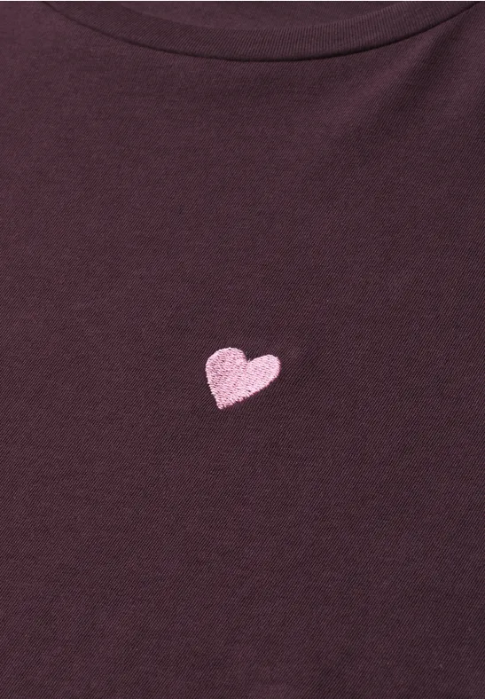 T-shirt violet foncé avec un petit cœur rose au centre.