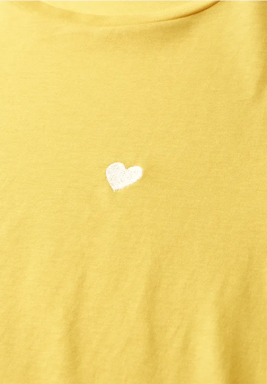 T-shirt jaune avec un petit cœur blanc brodé au centre