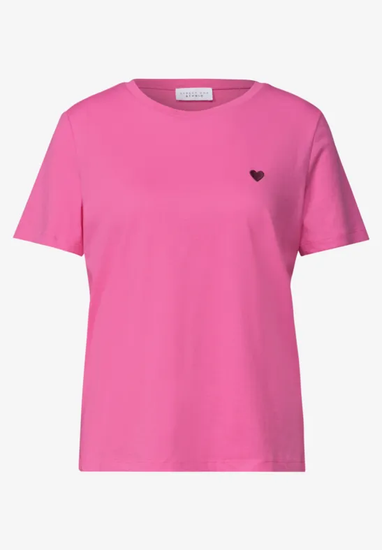 T-shirt rose simple à manches courtes avec petit cœur noir sur la poitrine.