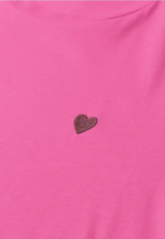 Un t-shirt rose avec un petit cœur centré.