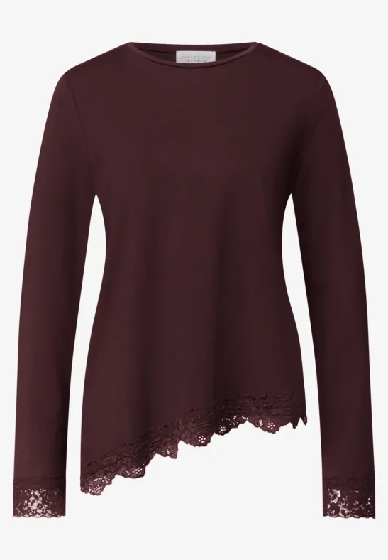 Donkerrood damesshirt met lange mouwen, asymmetrische zoom en kanten afwerking onderaan en bij de mouwen.