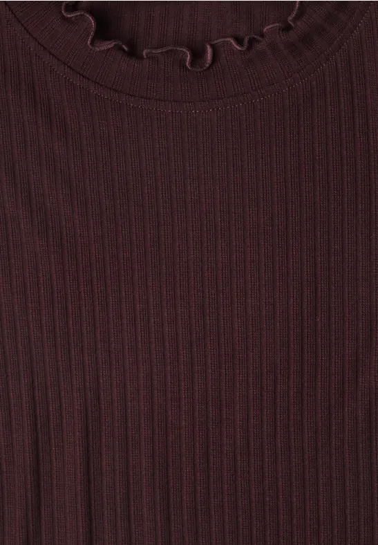 Nahaufnahme eines dunkelroten, gerippten Strickshirts mit leicht gekräuseltem Rundhalsausschnitt.