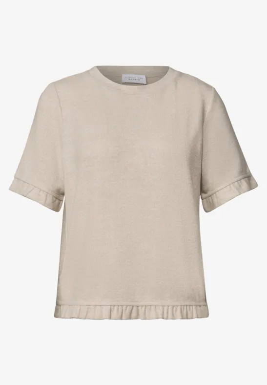 Beiges, kurzes T-Shirt mit kurzen Ärmeln und dezentem Rüschenabschluss am Saum.
