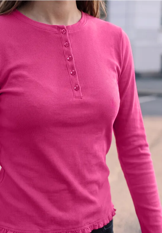 Roze longsleeve met knoopsluiting aan de ronde hals en een subtiel gerimpelde zoom.