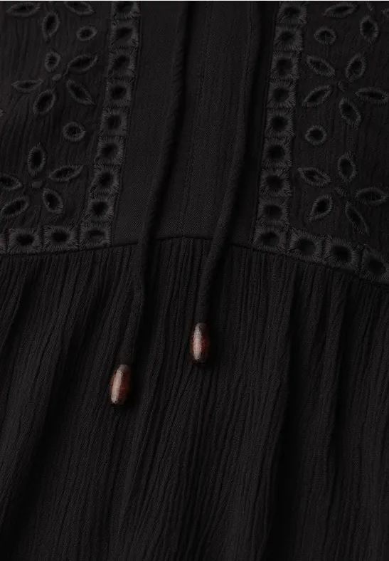 Schwarzes Kleid oder Top mit Lochstickerei, Crinkle-Stoff und Kordeln mit braunen Holzperlen.