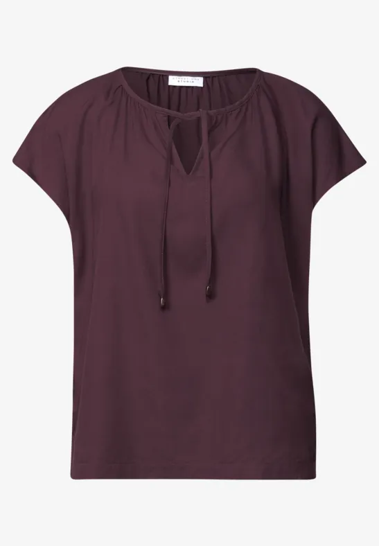 Dunkles pflaumenfarbenes Damen-Shirt mit legerem Schnitt, kurzen Ärmeln und Tunnelzug am V-Ausschnitt.
