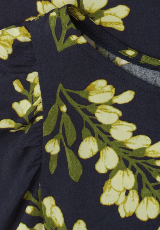 Donkerblauwe stof met geel-witte bloemen en groene bladeren als decoratieve print.