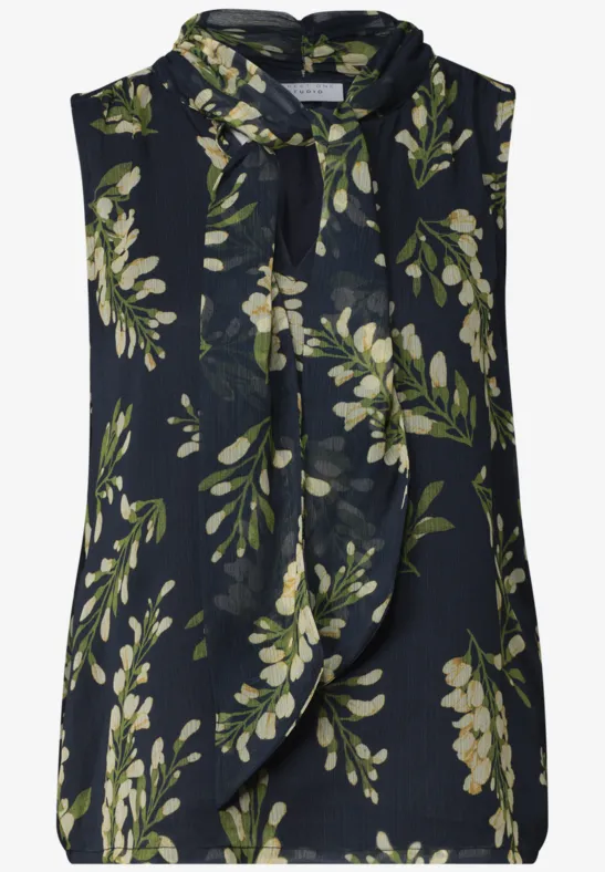 Dunkelblaue ärmellose Bluse mit grünem Blattmuster und Schleifenkragen.