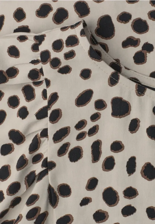 Beige stof met onregelmatige zwarte en bruine vlekken