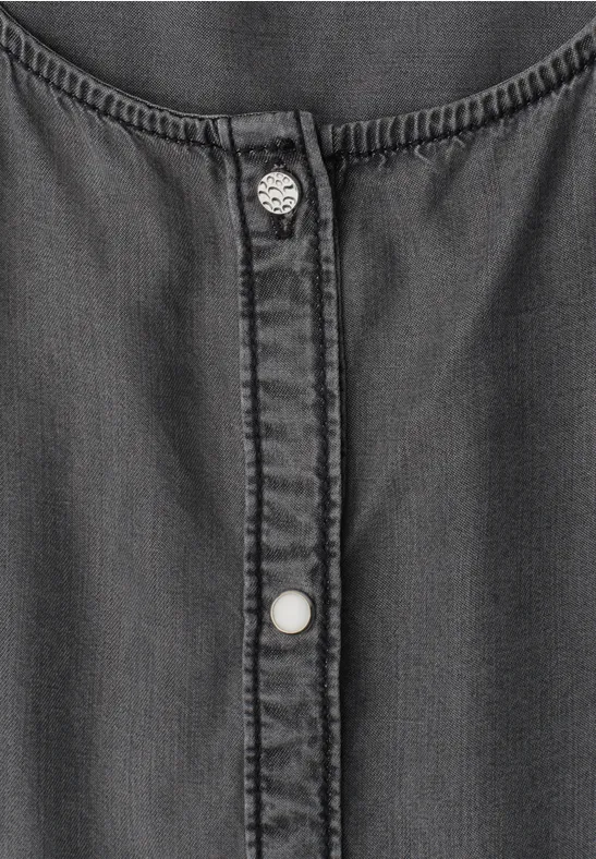 Graues Denim-Oberteil mit Knopfleiste und zwei silbernen Druckknöpfen.