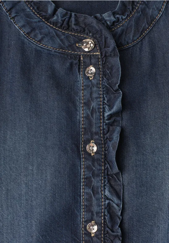 Dunkelblaue Denim-Bluse mit Rüschen am Kragen und funkelnden Metallknöpfen.
