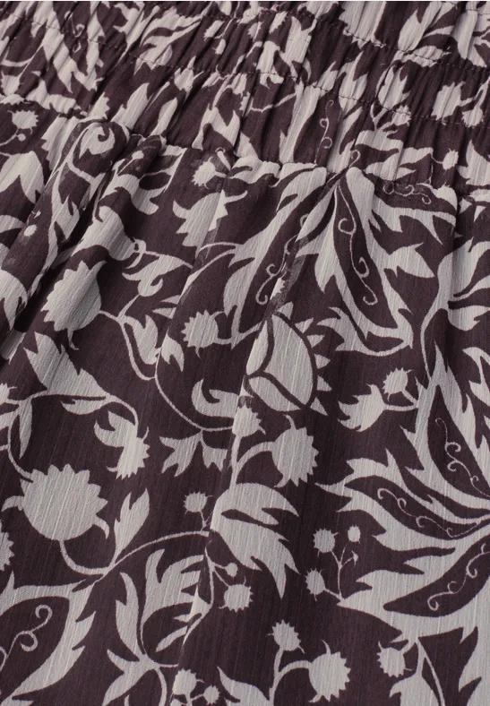 Close-up van zwart-witte bloemenprint op geplooide stof.