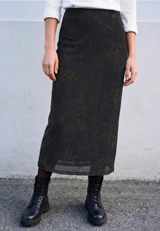 Schwarzer, leicht transparenter Midi-Rock mit dezentem Blumenmuster und schwarzen Schnürstiefeln.