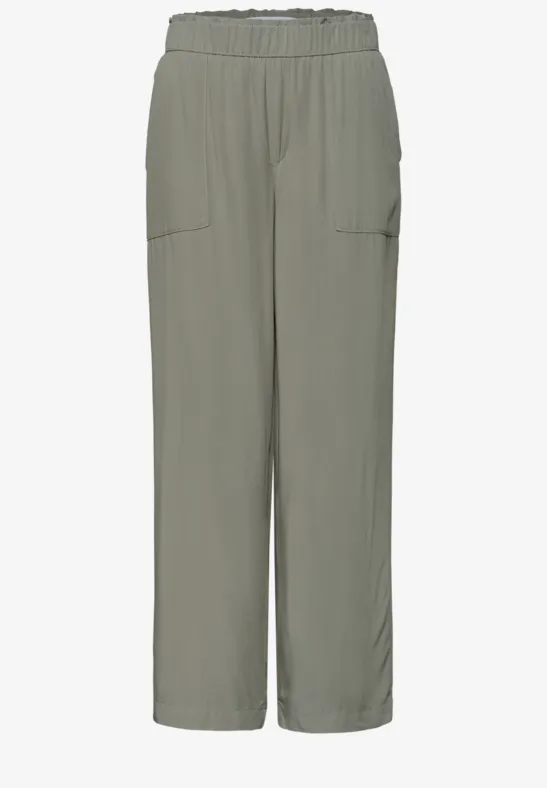 Locker sitzende, hellgrau-grüne Hose mit elastischem Bund und seitlichen Taschen.