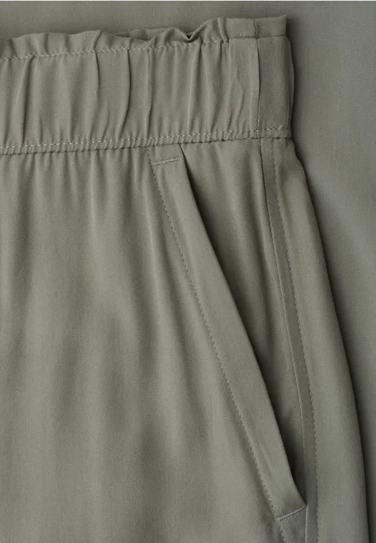 Nahaufnahme von grünlichen Hosen mit Gummibund und Tasche.