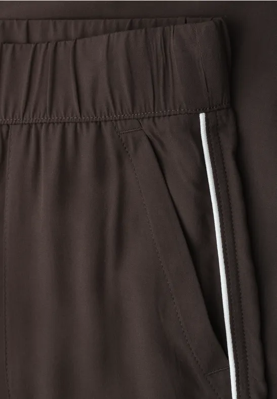 Braune Sporthose mit elastischem Bund und seitlicher Tasche mit weißem Streifen.