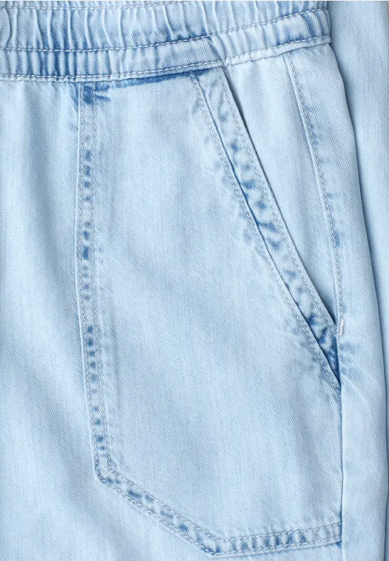 Lichtblauwe jeansbroek met elastische taille en een zijzak.