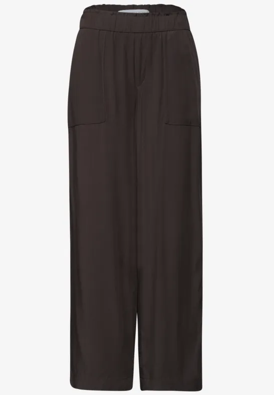 Zwarte, wijde broek met elastische taille en voorzakken.