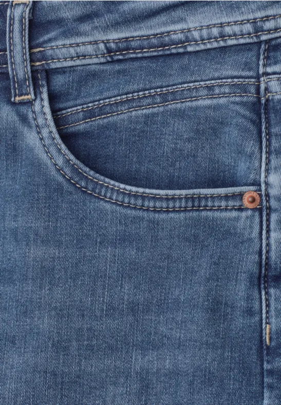 Gros plan sur un jean bleu avec poche visible.