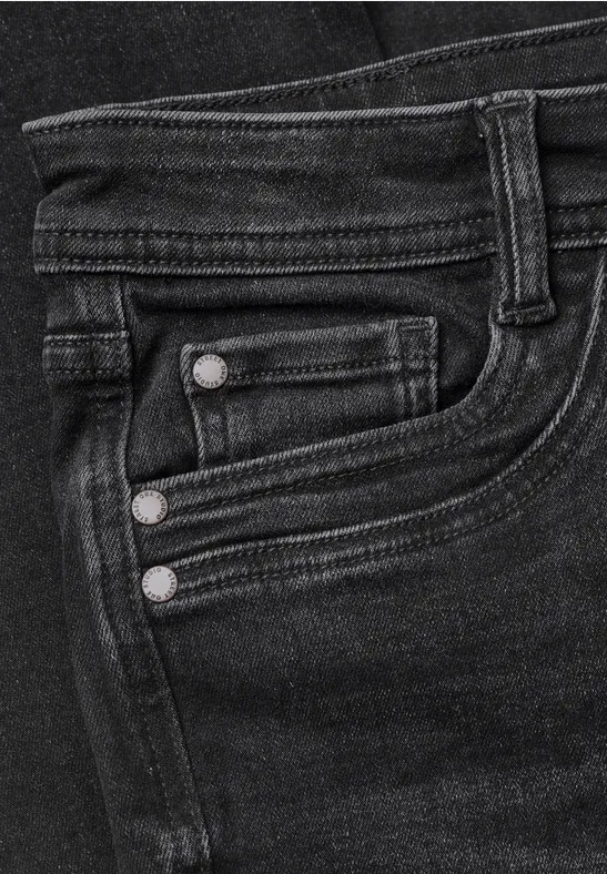 Nahaufnahme einer dunklen Jeansvorderseite mit Münztasche, Gürtelschlaufe und Nieten.