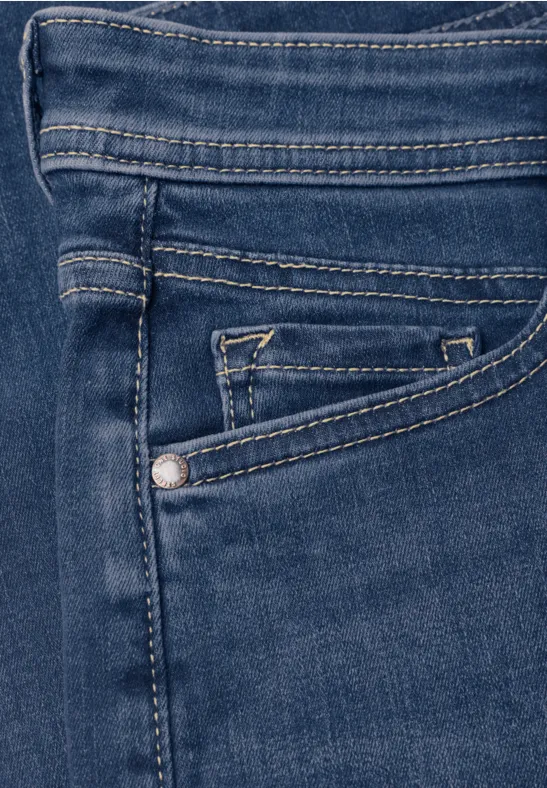 Nahaufnahme einer dunkelblauen Jeansvordertasche mit Münzfach und auffälligen Nähten.