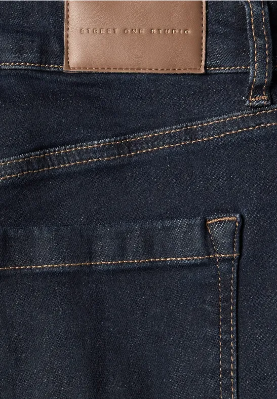 Nahaufnahme einer dunkelblauen Jeans, Fokus auf Tasche und Lederetikett 'Street One'.
