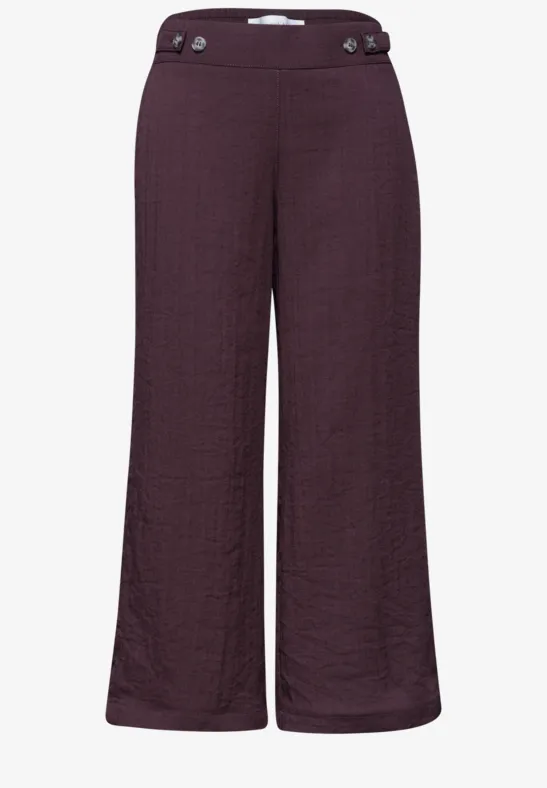 Dunkelviolette, weit geschnittene Damenhose mit hohem Bund und Knopfdetails.