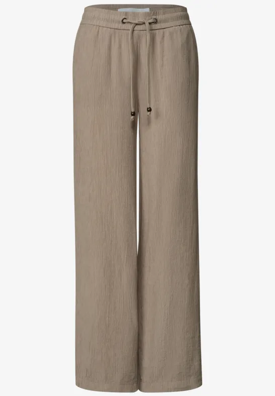 Helle beige Leinenhose mit weitem Schnitt und Kordelzugbund.