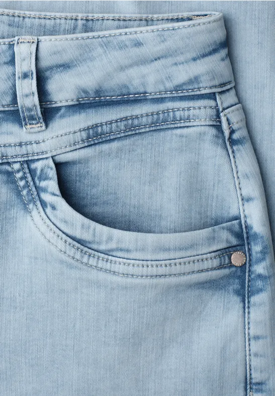 Nahaufnahme einer hellblauen Jeanshosentasche mit sichtbarer Naht und Gürtelschlaufen