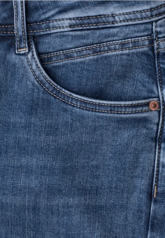 Nahaufnahme einer blauen Jeanshose mit sichtbarer Seitentasche und Nähten.
